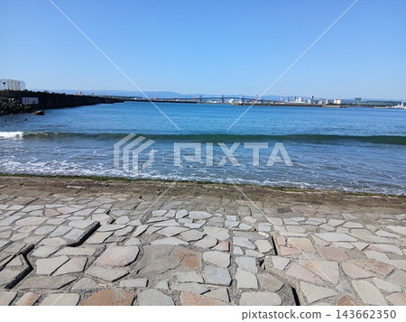 A seaside landscape with a clear blue sky and gentle waves. A seaside landscape with a clear blue sky and gentle waves. 143662350