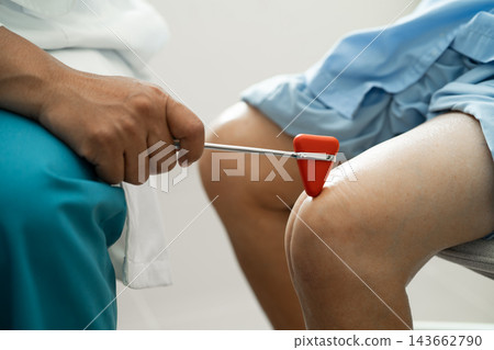 Asian doctor physiotherapist examining, massaging and treatment knee and leg of senior patient in orthopedist medical clinic nurse hospital. Asian doctor physiotherapist examining, massaging and treatment knee and leg of senior patient in orthopedist medical clinic nurse hospital. 143662790