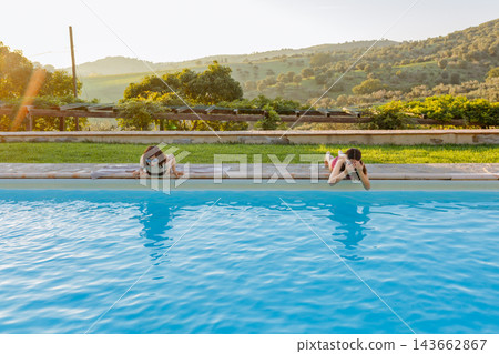 Girls wearing goggles at swimming pool in countryside Girls wearing goggles at swimming pool in countryside 143662867