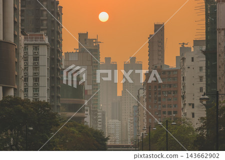 Hong Kong Oct 13 2026 Glowing Crimson Sun Setting Between High Rise Skyscrapers Hong Kong Oct 13 2026 Glowing Crimson Sun Setting Between High Rise Skyscrapers 143662902