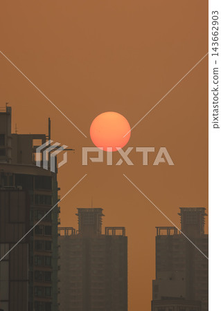 Hong Kong Oct 13 2026 Glowing Crimson Sun Setting Between High Rise Skyscrapers Hong Kong Oct 13 2026 Glowing Crimson Sun Setting Between High Rise Skyscrapers 143662903