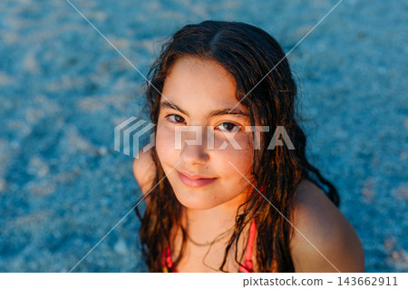 Close Up Portrait of a Happy Child Sitting on a Beach at Sunset Close Up Portrait of a Happy Child Sitting on a Beach at Sunset 143662911