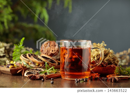 Herbal tea on an old wooden table with dried herbs, flowers, and spices. Herbal tea on an old wooden table with dried herbs, flowers, and spices. 143663522
