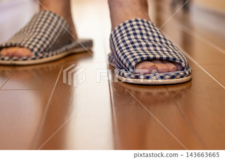 The feet of a person wearing slippers The feet of a person wearing slippers 143663665