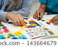 Asian elderly woman playing game with caregiver for train memory. 143664679