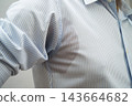 Man with sweat on clothes under armpit when working in office. 143664682
