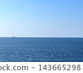 A calm horizon stretches out before you, with the blue sea and clear sky. 143665298