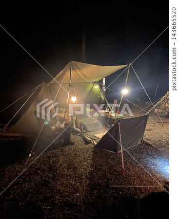 The warm glow of lanterns illuminates the quiet nighttime campsite. The warm glow of lanterns illuminates the quiet nighttime campsite. 143665520