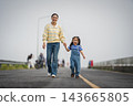 mother and preschool child girl holding hand and walking on a road on mountain in morning 143665805