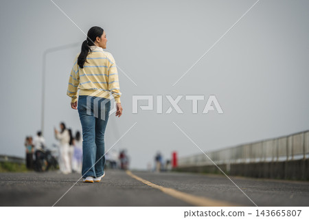 woman walking on a road on mountain in morning 143665807