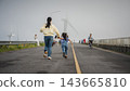 mother and preschool child girl holding hand and running on a road on mountain in morning 143665810