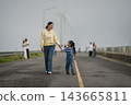 mother and preschool child girl holding hand and walking on a road on mountain in morning 143665811