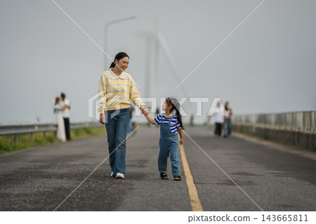 mother and preschool child girl holding hand and walking on a road on mountain in morning mother and preschool child girl holding hand and walking on a road on mountain in morning 143665811