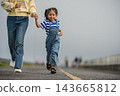 mother and preschool child girl holding hand and running on a road on mountain in morning 143665812