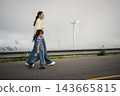 mother and preschool child girl holding hand and walking on a road on mountain in morning 143665815
