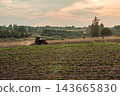 Tractor in Scenic Rural Field at Sunset 143665830