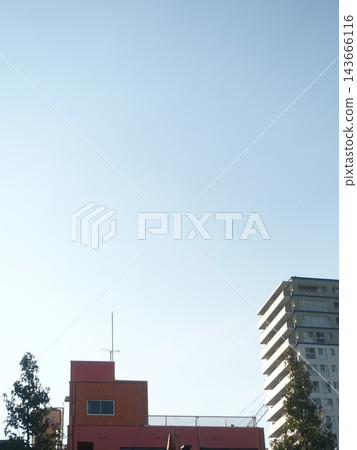 紅色高樓和白色公寓大樓在明亮的天空下並肩而立。 143666116