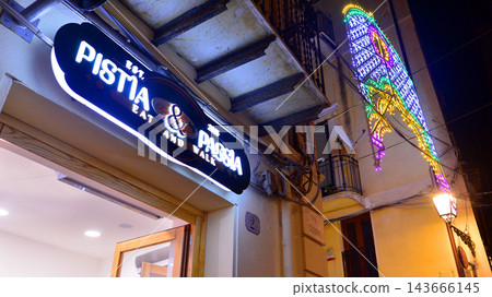 Cefalu, Italy. 22 August 2026. Urban landscape. Neon sign with the inscription: Pistia and Passia. Cefalu, Italy. 22 August 2026. Urban landscape. Neon sign with the inscription: Pistia and Passia. 143666145