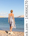 Happy carefree woman enjoying late afternoon walk on white pabbled beach on Pag island, Croatia. 143666270