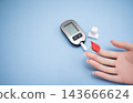 Diabetes concept with blood glucose meter, sugar cubes, blue awareness ribbon and medical gloves on blue background 143666624