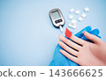 Diabetes concept with blood glucose meter, sugar cubes, blue awareness ribbon and medical gloves on blue background 143666625