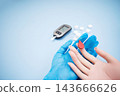 Diabetes concept with blood glucose meter, sugar cubes, blue awareness ribbon and medical gloves on blue background 143666626