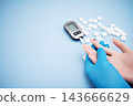 Diabetes concept with blood glucose meter, sugar cubes, blue awareness ribbon and medical gloves on blue background 143666629