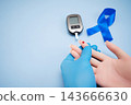 Diabetes concept with blood glucose meter, sugar cubes, blue awareness ribbon and medical gloves on blue background 143666630