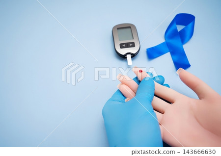 Diabetes concept with blood glucose meter, sugar cubes, blue awareness ribbon and medical gloves on blue background 143666630