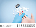 Diabetes concept with blood glucose meter, sugar cubes, blue awareness ribbon and medical gloves on blue background 143666635