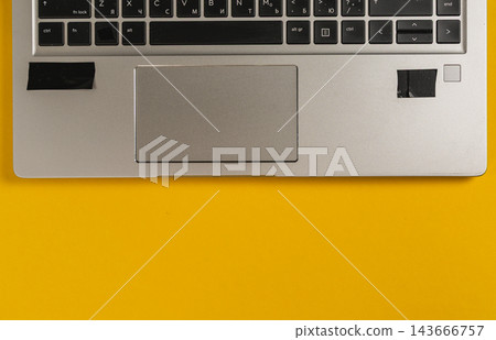 Laptop on a yellow desk with a simple setup for work and tasks 143666757