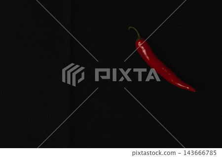 Red chili pepper on a black background with space for cooking design Red chili pepper on a black background with space for cooking design 143666785