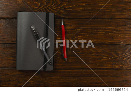 Workspace with pens and notebook on wooden desk Workspace with pens and notebook on wooden desk 143666824
