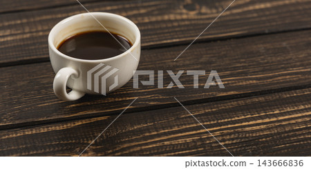 Cup of coffee on a wooden desk during morning work break Cup of coffee on a wooden desk during morning work break 143666836