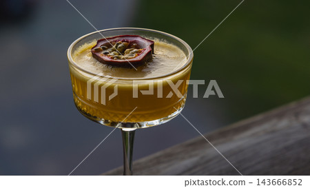 Enjoying a pornstar martini at a bar during a sunny outdoor gathering Enjoying a pornstar martini at a bar during a sunny outdoor gathering 143666852