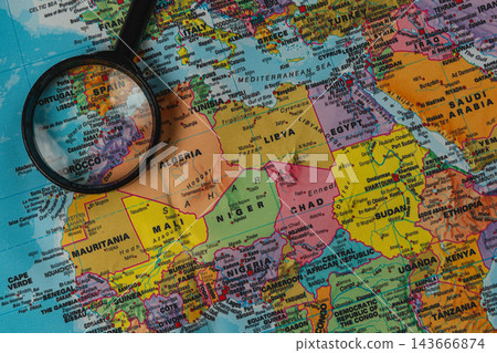 Exploring a world map with a magnifying glass to find locations Exploring a world map with a magnifying glass to find locations 143666874