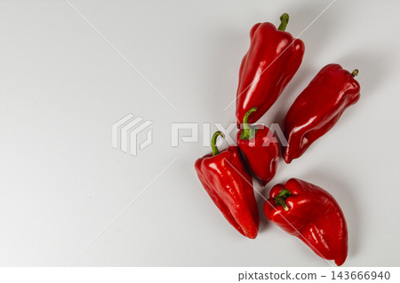 Red sweet peppers arranged on a white background 143666940