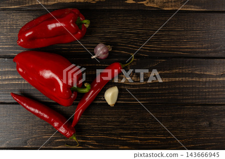 Peppers, chili and garlic arranged on a wood table Peppers, chili and garlic arranged on a wood table 143666945