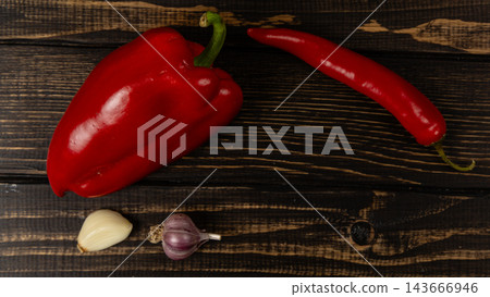 Pepper, chili, onion, and garlic on a wooden surface 143666946