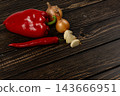 Pepper, chili, onion, and garlic on a wooden kitchen surface 143666951