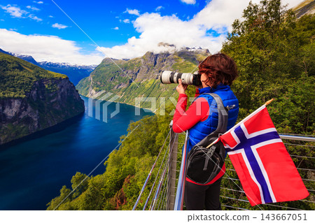 Tourist taking photo of fjord landscape, Norway Tourist taking photo of fjord landscape, Norway 143667051