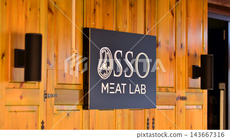 Cefalu, Italy. 21 August 2026. Urban landscape. Neon sign with the inscription: Osso Meat Lab. Cefalu, Italy. 21 August 2026. Urban landscape. Neon sign with the inscription: Osso Meat Lab. 143667316