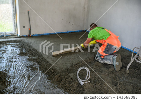 Construction Worker Pouring and Leveling Concrete Screed Floor Indoors Construction Worker Pouring and Leveling Concrete Screed Floor Indoors 143668083