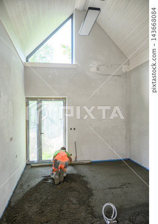 Construction Worker Pouring and Leveling Concrete Screed Floor Indoors Construction Worker Pouring and Leveling Concrete Screed Floor Indoors 143668084