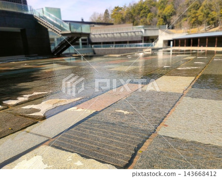 A modern cobblestone patio with flowing water. A modern cobblestone patio with flowing water. 143668412