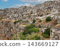 Matera ancient cave dwellings overlooking rugged ravine 143669127