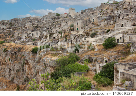 Matera ancient cave dwellings overlooking rugged ravine Matera ancient cave dwellings overlooking rugged ravine 143669127