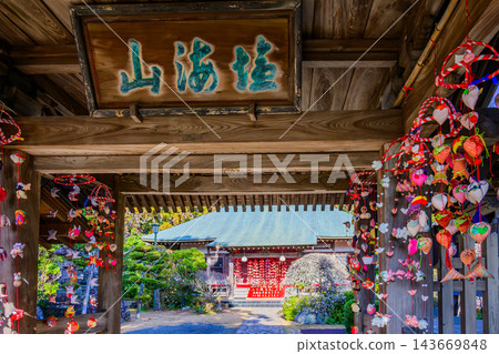 A New Year's scene capturing the temple grounds of Chishokuji Temple in Ninomiya Town during winter, with its gate adorned with beautiful hanging hina dolls and the majestic main hall standing beyond. A New Year's scene capturing the temple grounds of Chishokuji Temple in Ninomiya Town during winter, with its gate adorned with beautiful hanging hina dolls and the majestic main hall standing beyond. 143669848