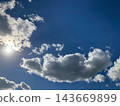 Blue sky, clouds, and a dazzling sun 143669899