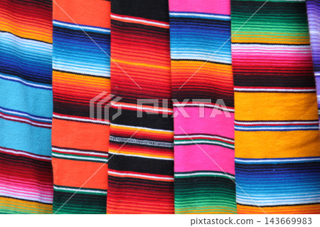 Colorful mexican serape blankets displaying vibrant striped textile pattern 143669983